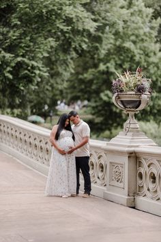 a man and woman standing next to each other on a bridge