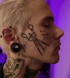 a man with tattoos and piercings on his face