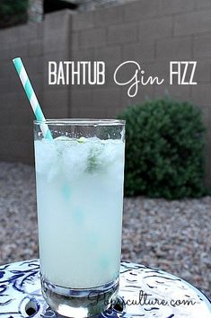 a tall glass filled with liquid sitting on top of a blue and white tablecloth