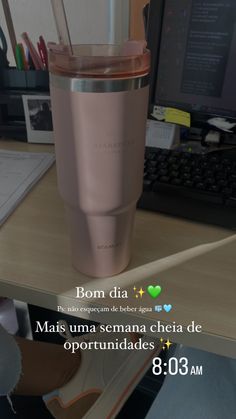 a pink tumbler cup sitting on top of a desk