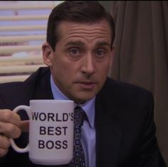 a man in a suit and tie holding a coffee mug with the words world's best boss on it