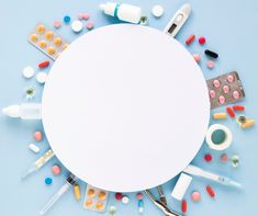 an overhead view of various medical supplies arranged in a circle on a light blue background