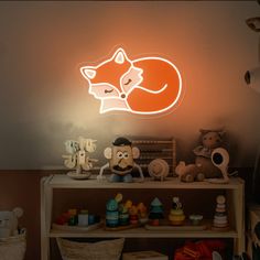 a neon sign with a sleeping fox on it's face next to other stuffed animals