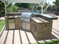 an outdoor kitchen with grill and sink