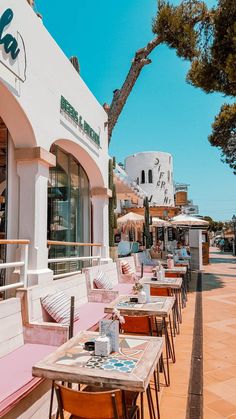 tables and chairs are lined up on the sidewalk