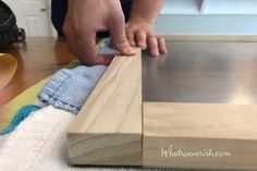 a person is sanding wood on top of a wooden table with a towel and cloth