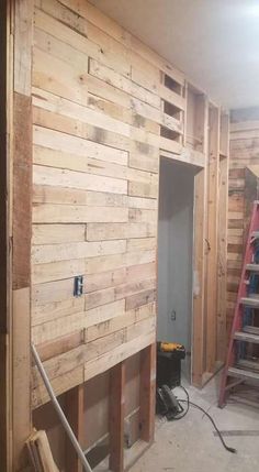 an unfinished room with wooden walls and ladders