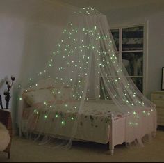 a bed with a white net and green lights on it