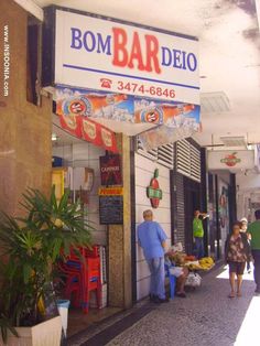 a man standing in front of a store next to a woman walking down the street