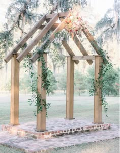 a wooden structure with flowers and greenery on it