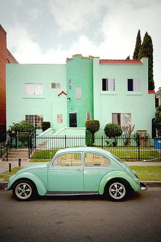 a green car parked in front of a house