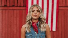 a woman standing in front of an american flag