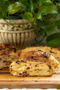 two pieces of bread sitting on top of a cutting board next to a potted plant