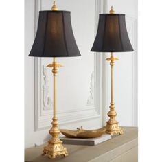 two lamps sitting on top of a table next to each other with a black shade