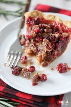 a piece of pie with cranberry topping on a plate next to a fork