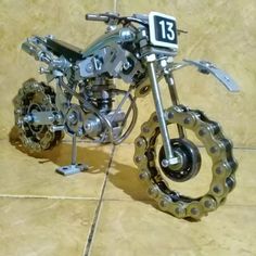 a motorcycle made out of metal parts on a tile floor next to a number 13 sign