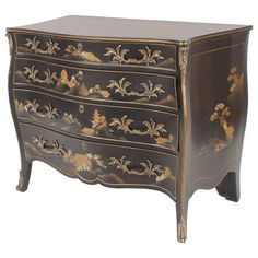 an ornate black and gold painted chest of drawers