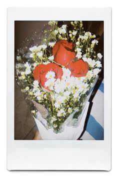 a bouquet of red roses and white daisies