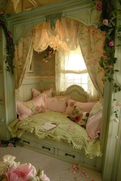 a bed with pink flowers on the covers and pillows in a room that has green walls