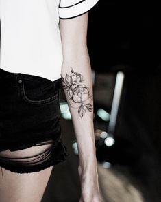 a woman with a flower tattoo on her arm