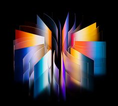 an open book with multicolored pages on black background