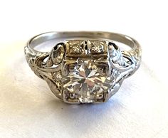 an antique style diamond ring with filigrees