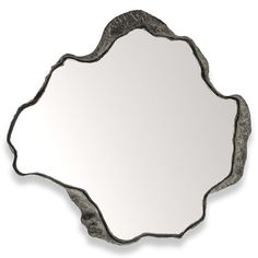 a mirror that is sitting on top of a white wall with an ornate design in the middle