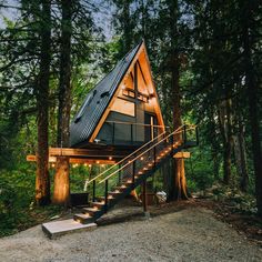 a small cabin in the woods with stairs leading up to it