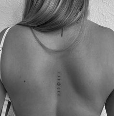 the back of a woman's shoulder with three different symbols on her left side