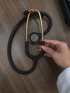 a person holding a stethoscope on top of a wooden table