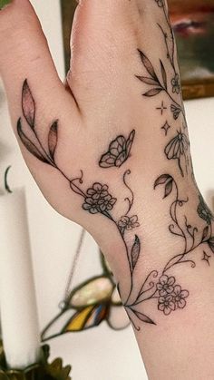 a woman's hand with a flower tattoo on it