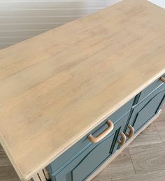 a wooden counter top sitting on top of a kitchen floor next to a white wall