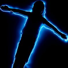 a person standing in the dark with their arms outstretched