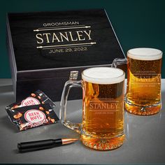 two beer mugs with personalized chocolate bar next to it on a gray surface