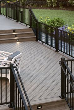 a white chair sitting on top of a wooden floor next to stairs and railings