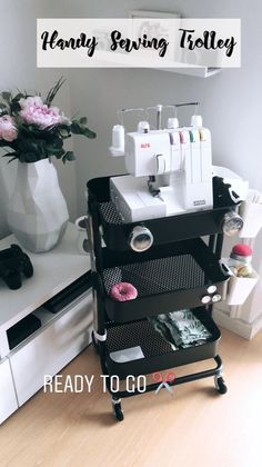 a sewing machine sitting on top of a table next to a vase filled with flowers