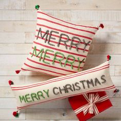 two christmas pillows with merry message on them