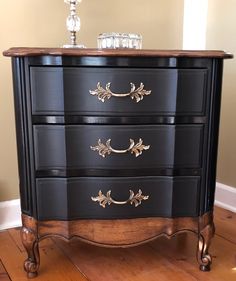 a black dresser with gold trim and drawers