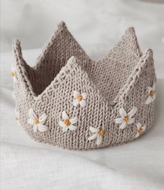 a knitted crown sitting on top of a bed