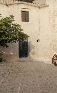 an old building with a tree in front of it