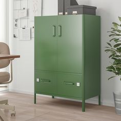 a green cabinet sitting in the corner of a room next to a desk and chair