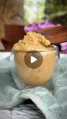 a glass jar filled with food sitting on top of a green towel next to a wooden spoon