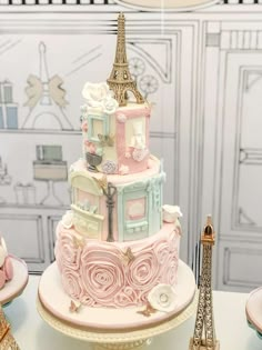 a pink and gold cake with the eiffel tower in the background