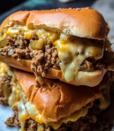 two cheeseburger sandwiches stacked on top of each other with melted cheese and ground beef