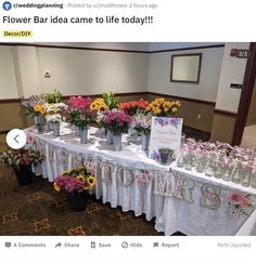 a table with flowers and vases on it in front of a sign that says flower bar