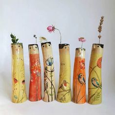 five vases with flowers and birds painted on them are lined up in a row