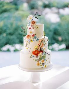 a white wedding cake with flowers on it