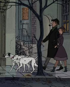 a man and woman walking two dogs down the street in front of a tree with no leaves on it