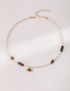 This vintage gold necklace is made of 925 silver and adorned with tiger eye stone, black agate, and a stunning natural pearl. The chain measures about 37cm, extendable by 7cm with an extension chain. The necklace features tiger eye stones sized around 4.5mm and 4.5mm by 15mm, complemented by a 20mm by 5.2mm pearl and an additional 4mm pearl. This elegant piece combines quality materials with a timeless design, perfect for any occasion. Material: 925 silver/tiger eye stone/black agate/natural pea Tiger Eye Necklace, Vintage Gold Necklace, Gold Tiger Eye, Tigers Eye Necklace, Baroque Pearl Earrings, Tiger Eye Beads, Tiger Eye Stone, Black Agate, Eye Stone