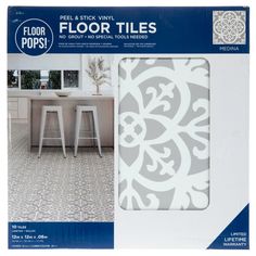 the package for floor tiles is shown in grey and white colors, with an ornate design on